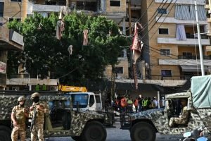 Soldados libaneses montam guarda enquanto equipes de resgate inspecionam os dano
