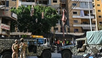 Soldados libaneses montam guarda enquanto equipes de resgate inspecionam os dano