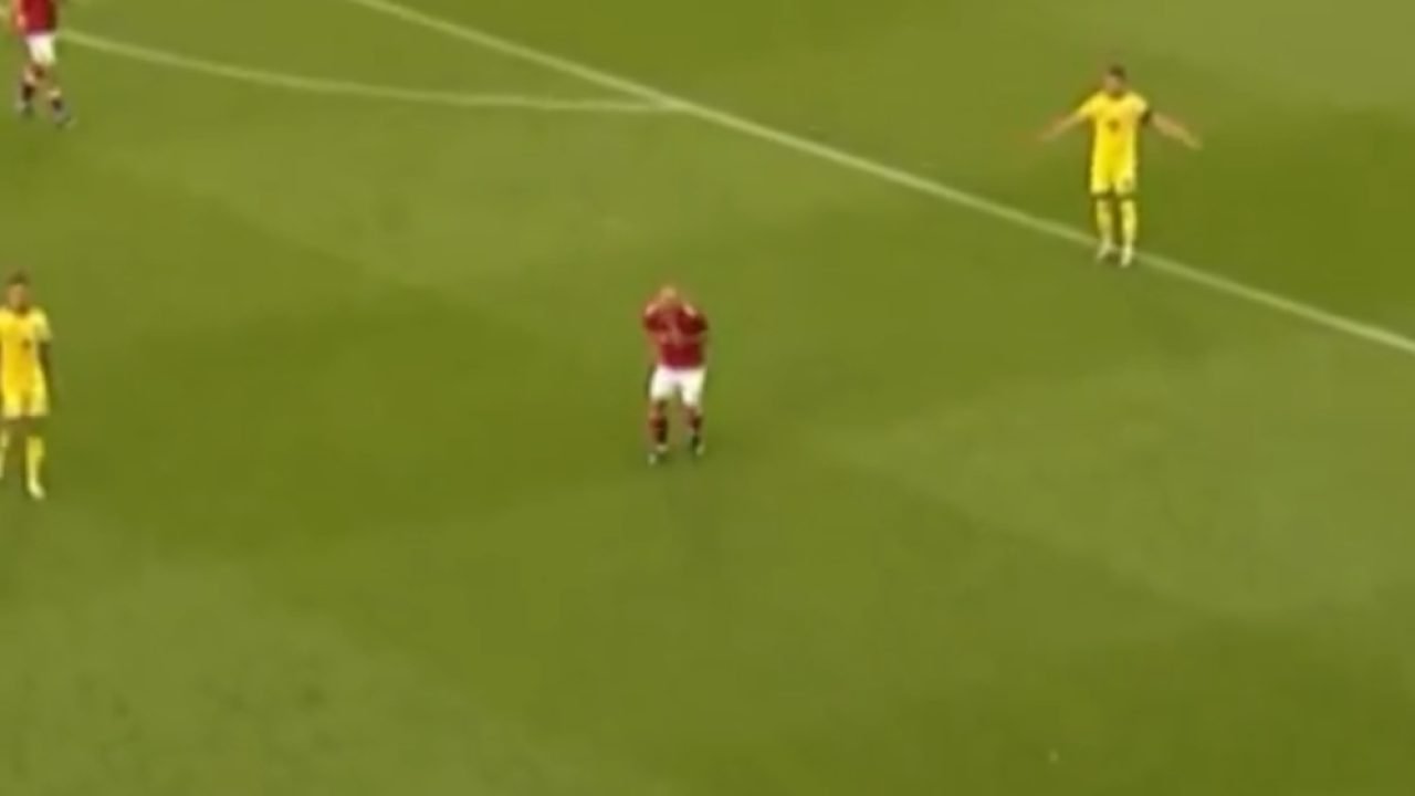 Eriksen leva a mão ao peito momentos antes de desmaiar em campo. — Foto: Eriksen