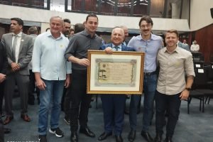 Da esquerda para a direita: o secretário de Transportes Adilson Poleze, o prefeito de Quedas do Iguaçu Rafael Moura, o homenageado Lauri Francisco Paludo, o presidente da Câmara de Quedas do Iguaçu Rodolfo Revers e o secretário de Administração Cris Colsenti.