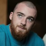 Foto colorida de Angus Cloud. O ator está de cabelo raspado e usa moletom. — Fot