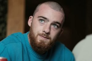 Foto colorida de Angus Cloud. O ator está de cabelo raspado e usa moletom. — Fot