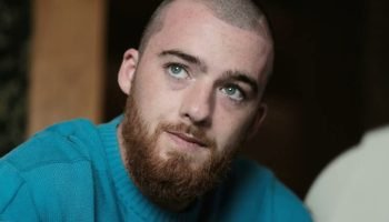 Foto colorida de Angus Cloud. O ator está de cabelo raspado e usa moletom. — Fot