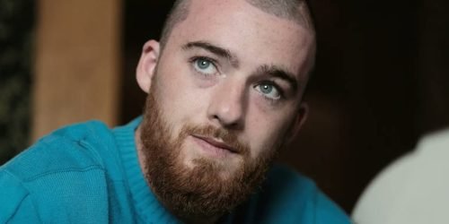 Foto colorida de Angus Cloud. O ator está de cabelo raspado e usa moletom. — Fot