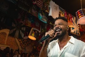 Foto colorida do cantor Arlindinho. No palco, ele canta em um microfone. — Foto: