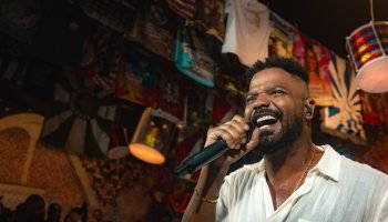 Foto colorida do cantor Arlindinho. No palco, ele canta em um microfone. — Foto: