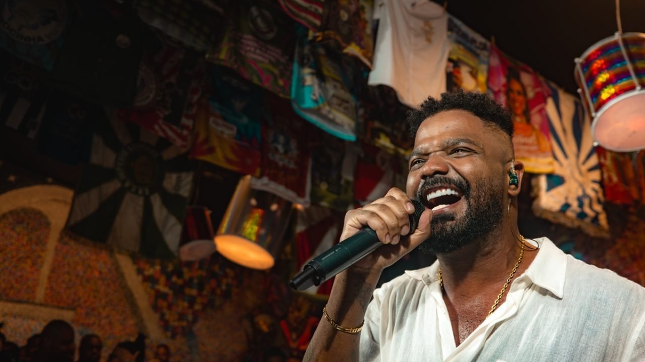 Foto colorida do cantor Arlindinho. No palco, ele canta em um microfone. — Foto: