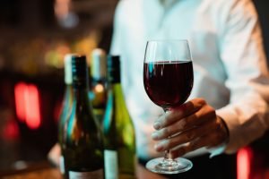 barman-segurando-o-copo-de-vinho-tinto