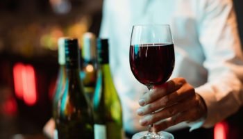 barman-segurando-o-copo-de-vinho-tinto