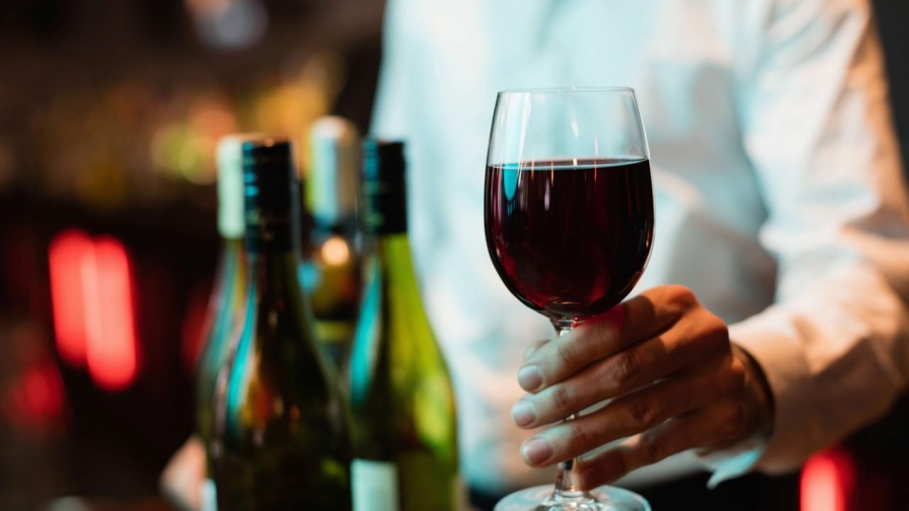 barman-segurando-o-copo-de-vinho-tinto