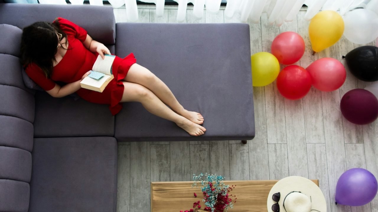 Pessoa descansando no sofá enquanto eventos ao redor não são acompanhados. — Fot