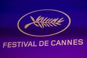 Imagem colorida de Logo do Festival de Cannes exibida durante a coletiva — Foto: