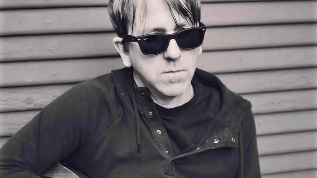 Greg Brown de óculos escuros segurando guitarra — Foto: 1 de 1 Greg Brown de ócu