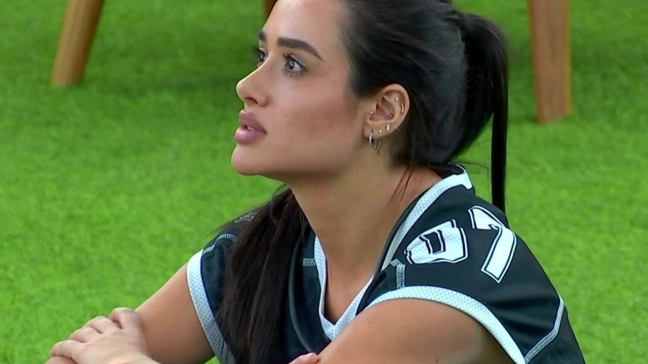 Foto: 1 de 1 Imagem colorida de Jordana sentada no gramado do BBB 26 - Metrópole