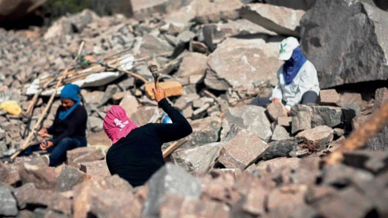 A imagem retrata a rotina das baianas que ganham a vida com a quebra de pedras n