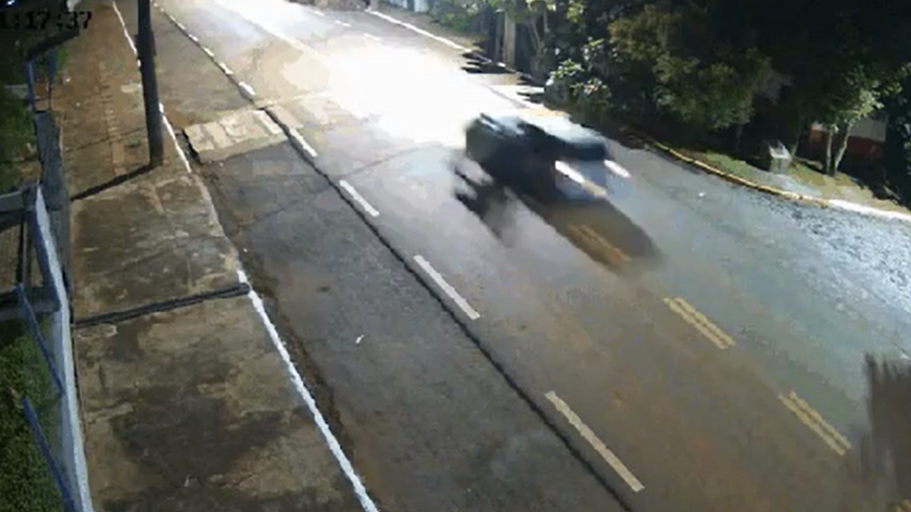 Imagens de uma câmera de segurança da região mostram o PM agarrado ao veículo em