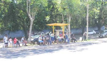 Via para pedestre danificada e, ao fundo, ponto de ônibus exposto ao sol — Foto: