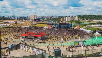 Imagem colorida do festival Lollapalooza, com um grande público em volta — Foto: