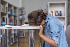 side-view-boy-sleeping-his-notebook