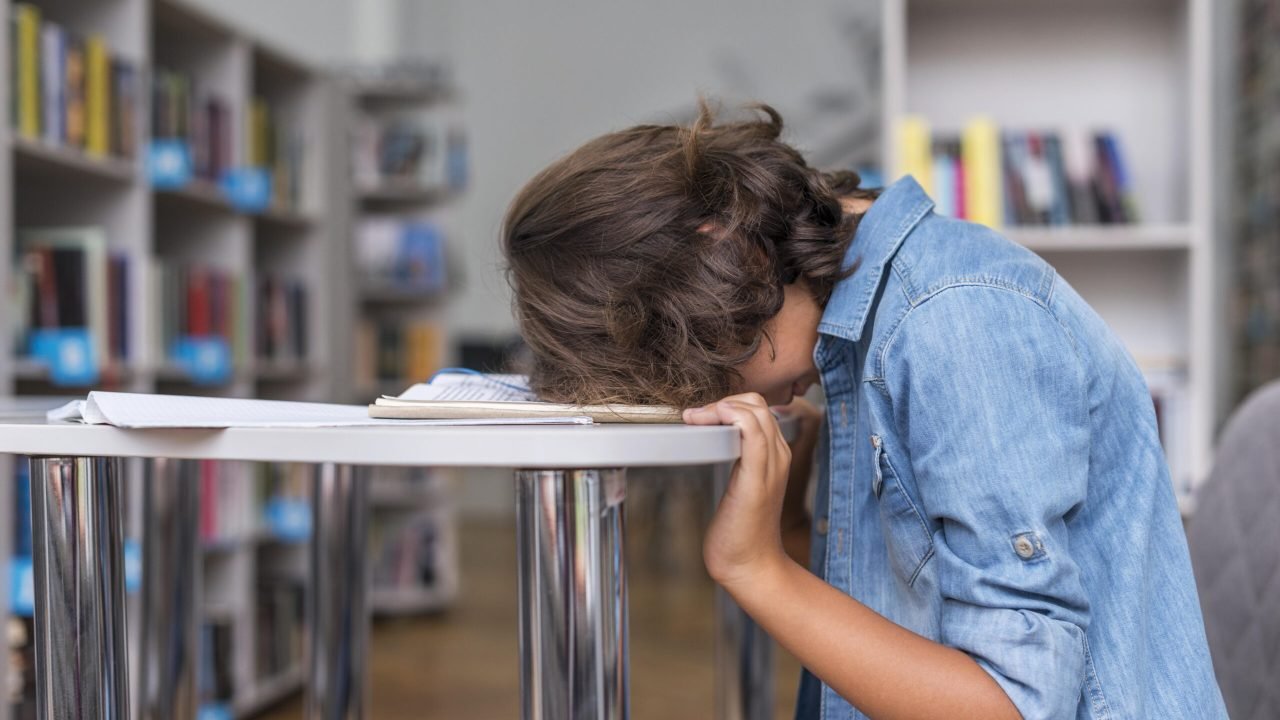 side-view-boy-sleeping-his-notebook