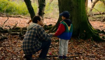 Imagem colorida mostra Jordan Bolger como André Hanscombe, Jahsaiah Williams com