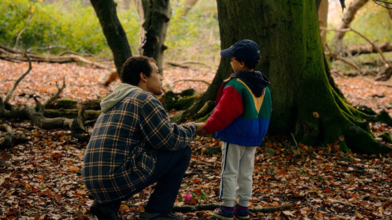 Imagem colorida mostra Jordan Bolger como André Hanscombe, Jahsaiah Williams com