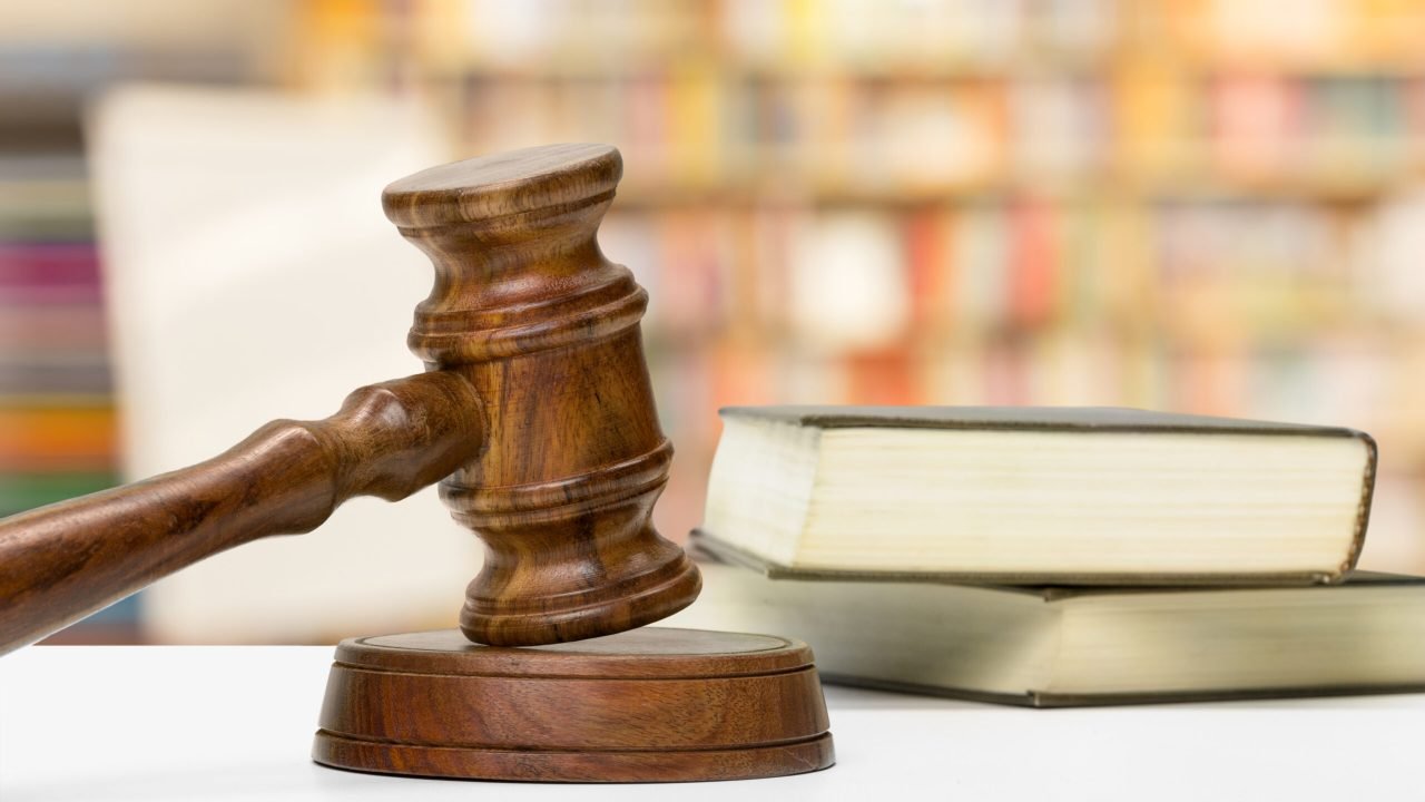 Wooden gavel and books on wooden table